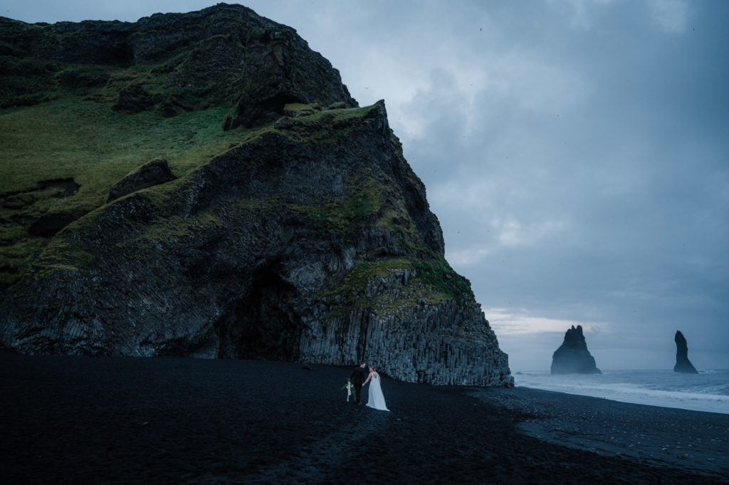 A couple is walking on the beach, ready to elope in Iceland!