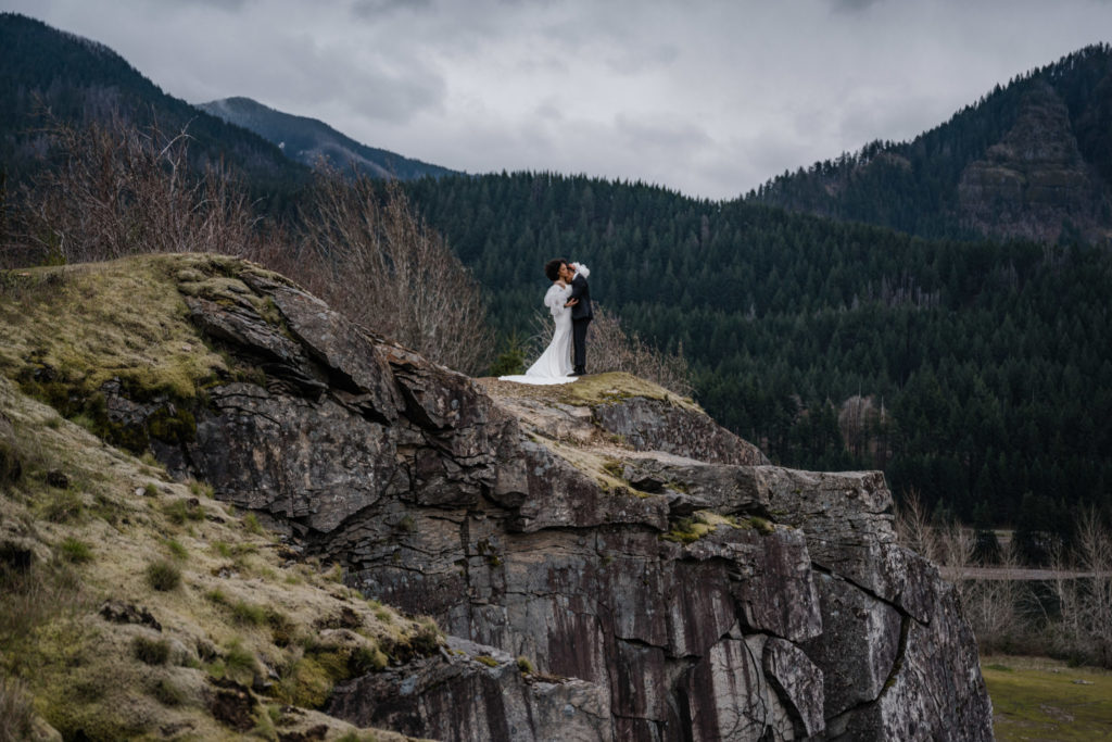 A couple standing on a cliff in Oregon, ready to elope.