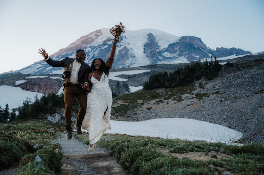 Couple jumping with joy after eloping in Mount Rainier National Park