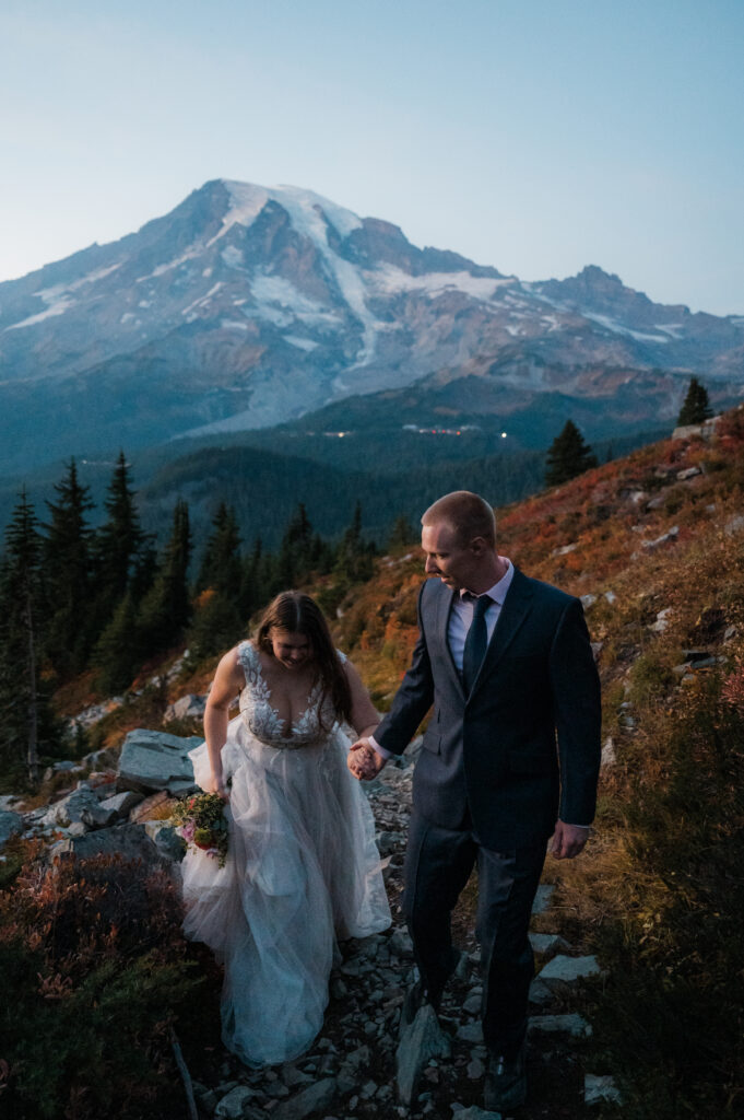 couple hiking in their wedding dress and suit in Mount Rainier National Park in the fall