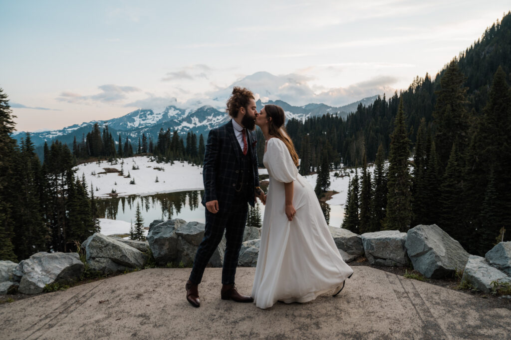 Couple sharing a kiss in front of Mount Rainier during their sunset elopement at Tipsoo Lake