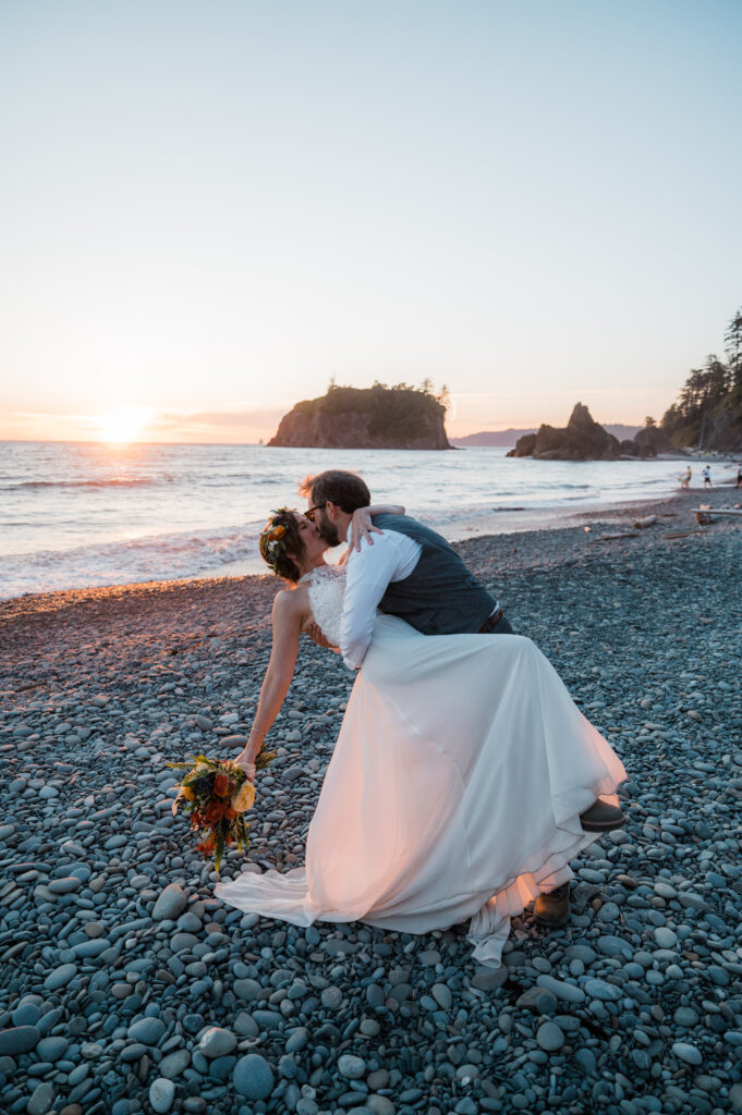 Couple kissing while the sun is setting at Ruby Beach during their elopement day in Olympic National Park