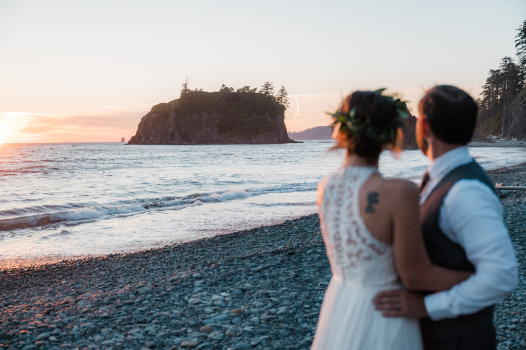 Couple watching the sunset together at Ruby Beach at the end of their elopement day in Olympic National Park