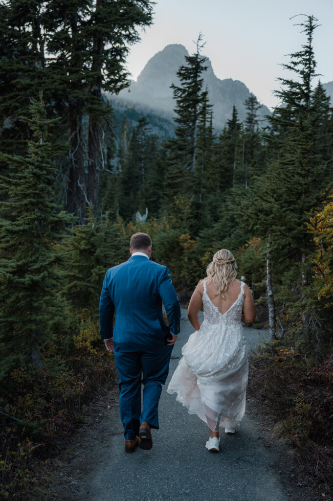 couple hiking in their wedding attire to their ceremony spot