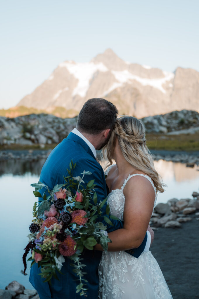 Couple eloped at Artist Point in Washington State holding flowers and looking at the mountains