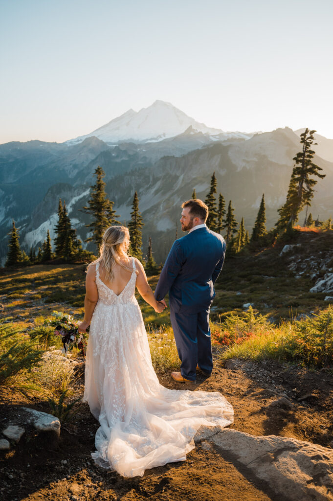 Bride and groom on their elopement day at Artist Point, looking at the views of Mt. Baker