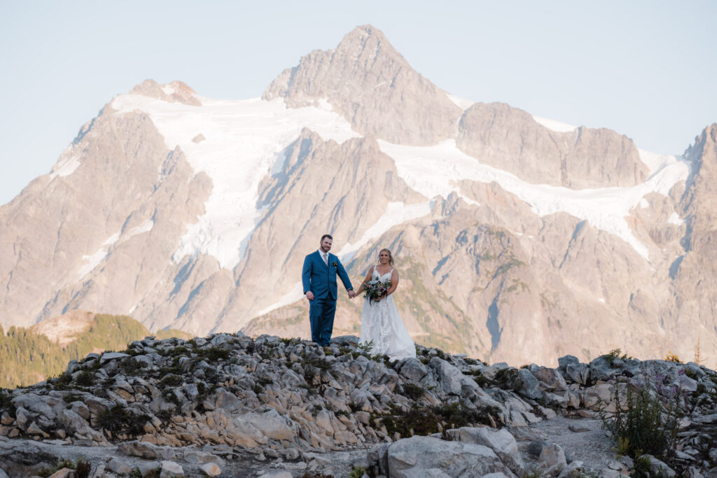 Eloping couple holding hands with views of Mount Shuksan in the background at Artist Point