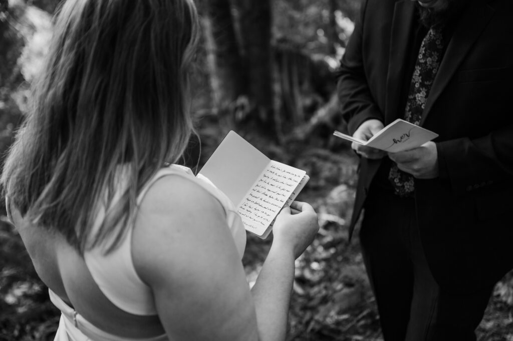 Couple reading their vows during their hiking elopement to Snoqualmie Falls