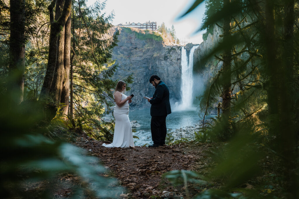 Couple reading their vows in front of Snoqualmie Falls while getting married in Washington State