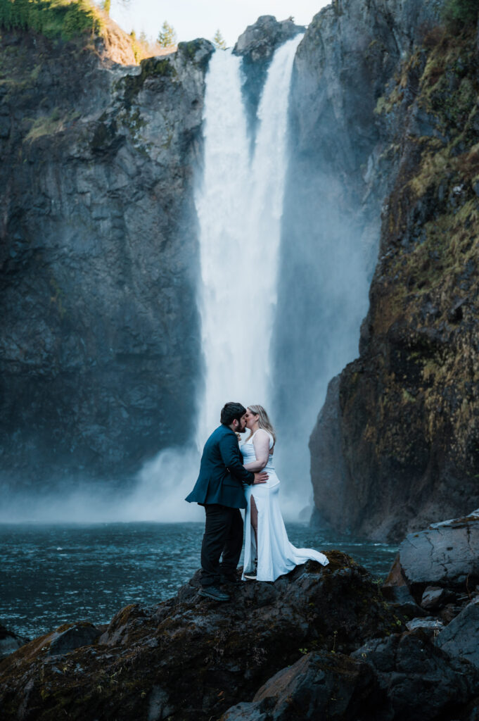 Couple kissing in front of Snoqualmie Falls on their elopement day