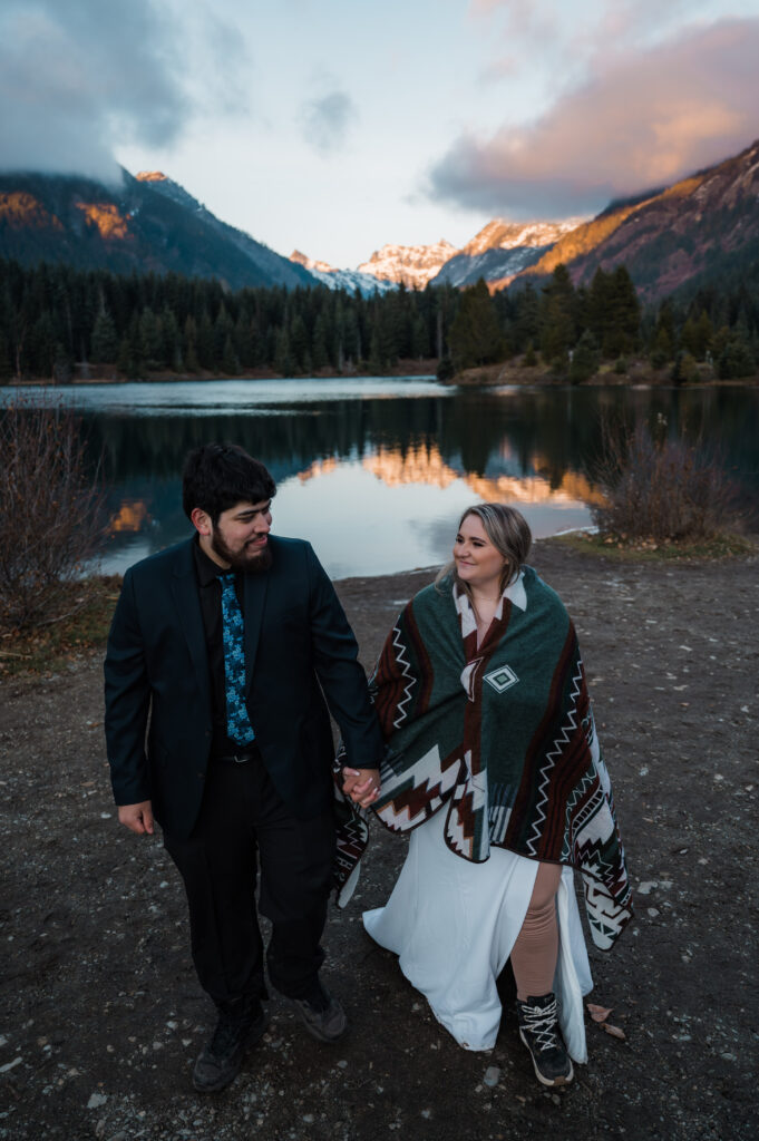 Bride and groom holding hands during sunset at Gold Creek Pond in Washington State