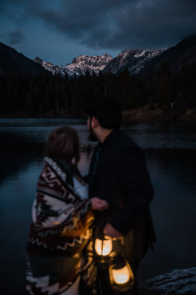 Bride and groom holding lanterns and enjoying the views at Gold Creek Pond after sunset