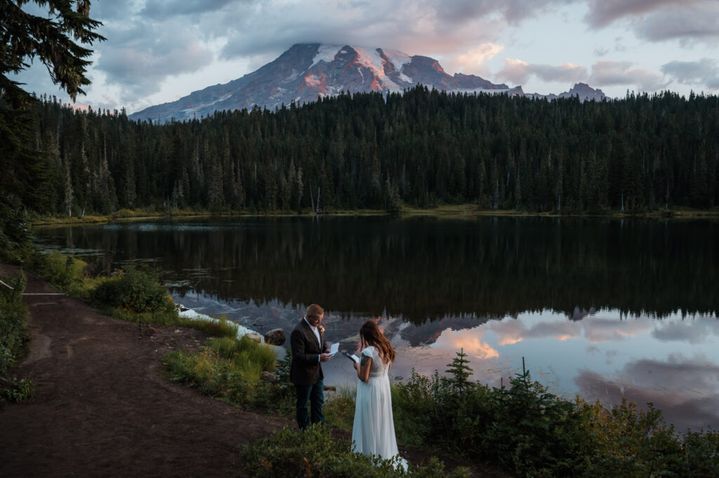 Couple exchanging vows during their wedding ceremony at Reflection Lake in Mount Rainier National Park