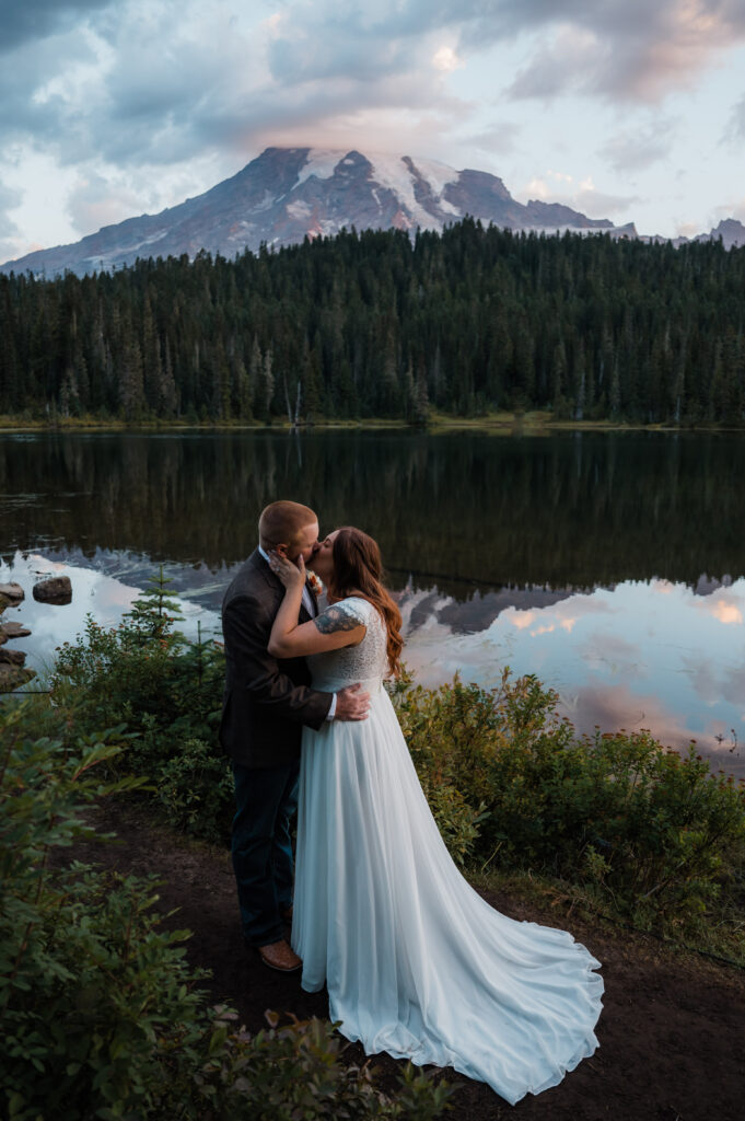 Bride and groom sharing their first kiss as a married couple at Reflection Lake in Mount Rainier National Park
