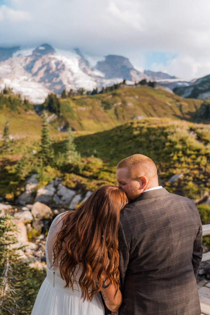 Bride and groom cozied up together while enjoying the views of Myrtle Falls and Mount Rainier 