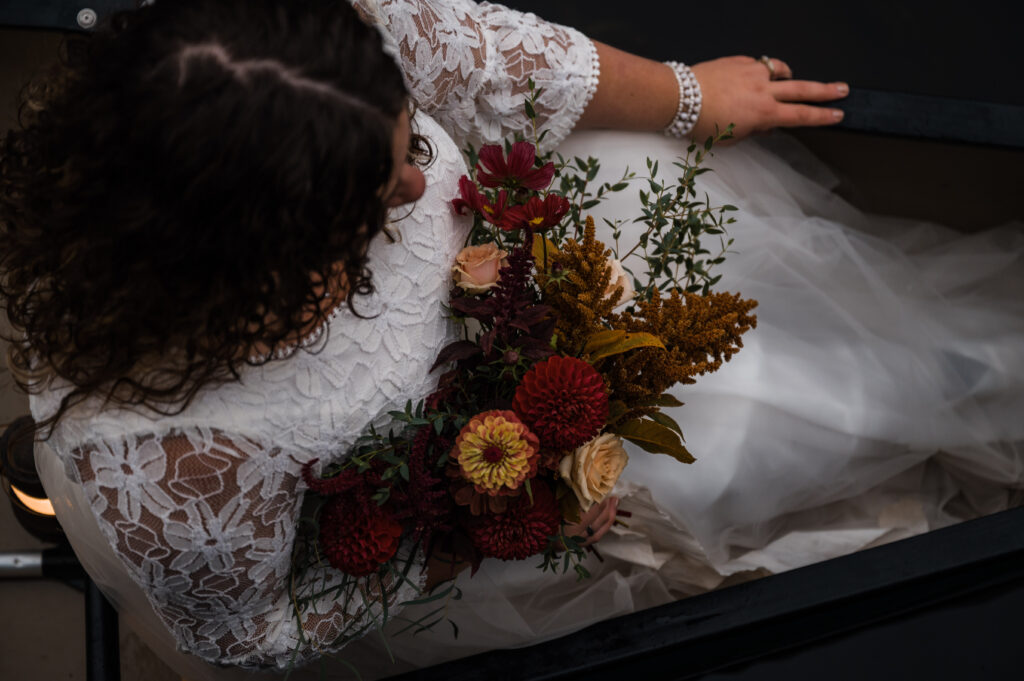 bride holding her bouquet while sitting in a canoe on her elopement day