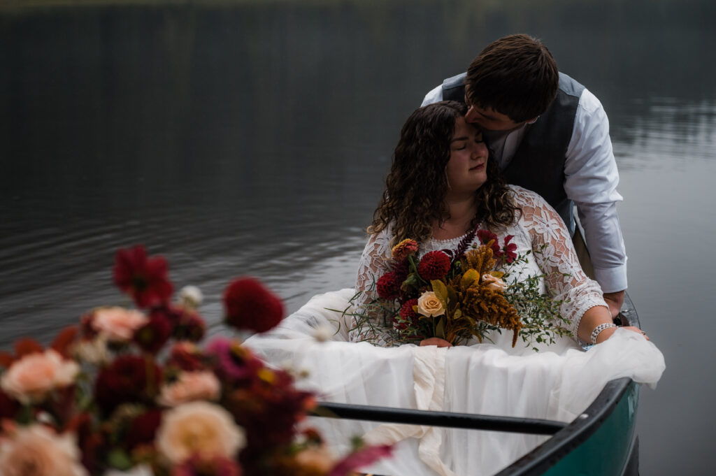 bride and groom sitting in a canoe during their elopement day at Trillium Lake