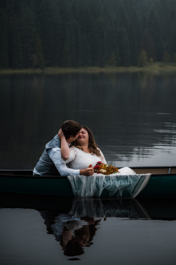 brides dress hanging over the side of a canoe during their elopement day at Trillium Lake