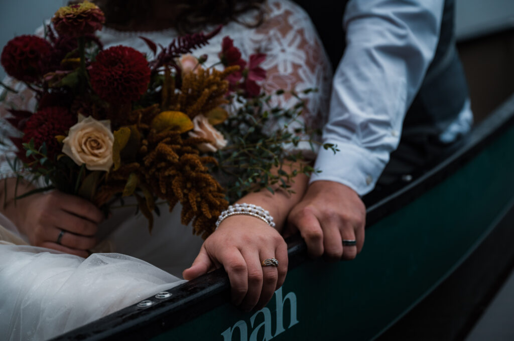 Bride and grooms rings on the side of a canoe