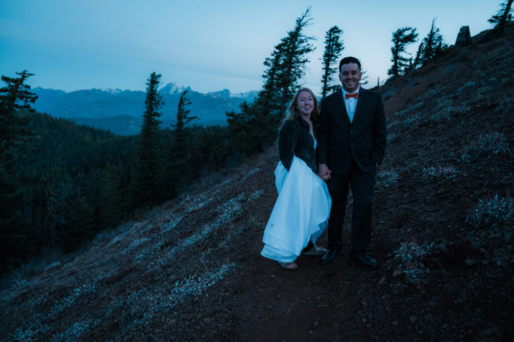 Bride and groom hiking up to a fire lookout on their elopement day