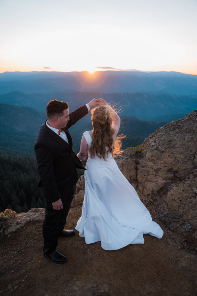 Newly married couple sharing their first dance at sunrise in the mountains in Washington