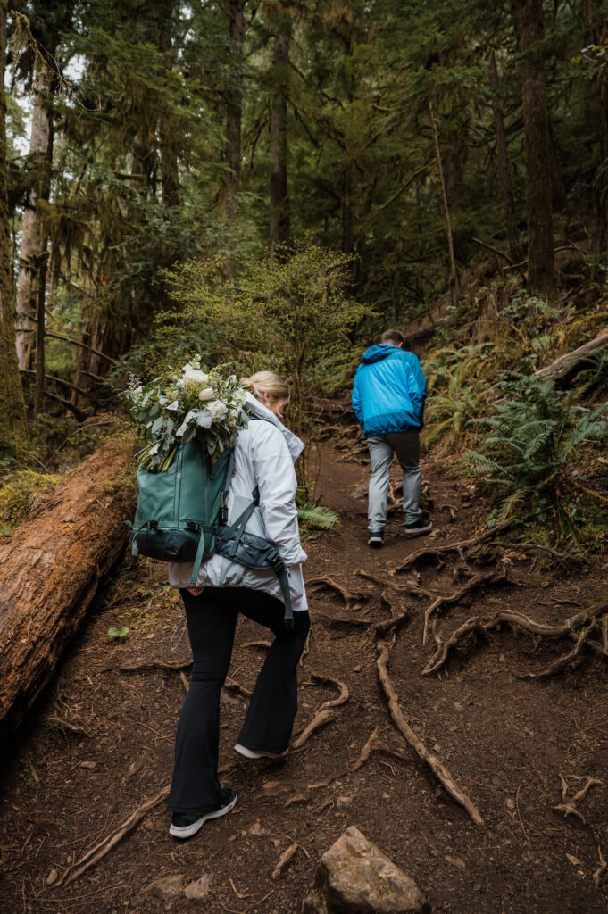 bride and groom wearing backpacks while hiking up to Mount Storm King in Olympic National Park during their elopement day 