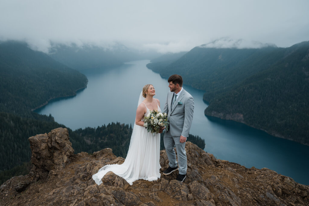 bride and groom standing at the top of Mount Storm King during their hiking elopement day in Olympic National Park