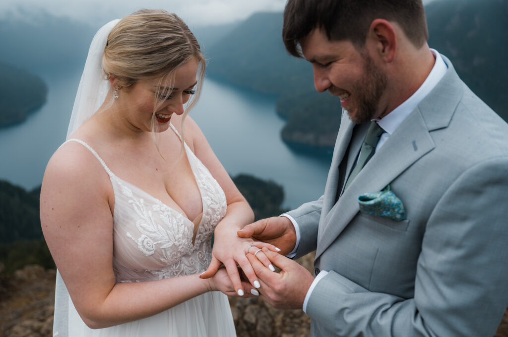 couple exchanging rings on top of Mount Storm King during their hiking elopement in Olympic National Park 