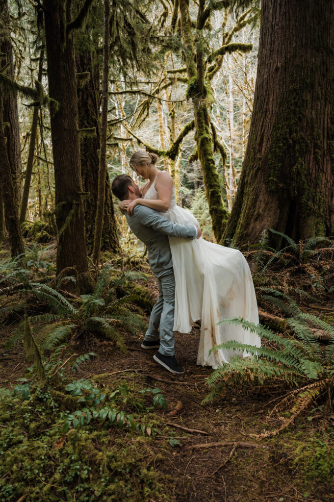 eloping couple posing for photos with mossy trees in Olympic National Park