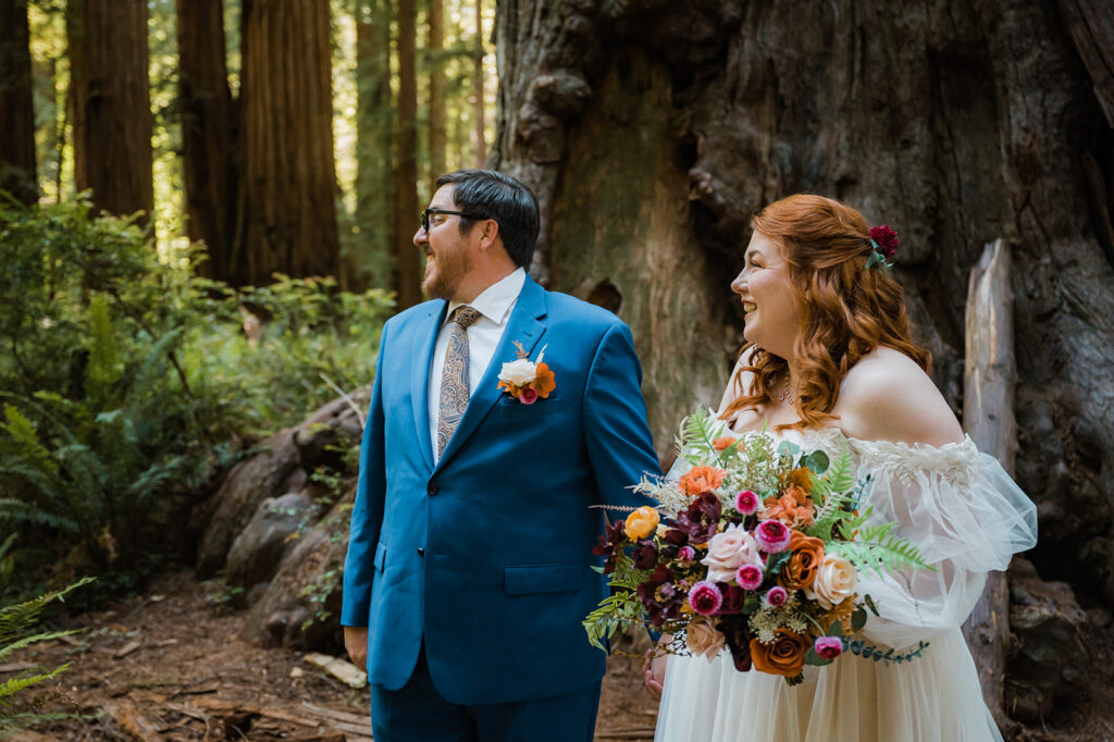 Couple walks through Redwood National Park in awe before their elopement ceremony