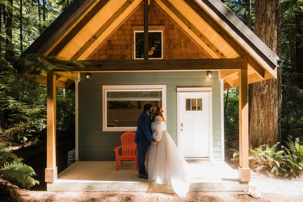 Couple stands on the porch of their Redwood National Park elopement airbnb