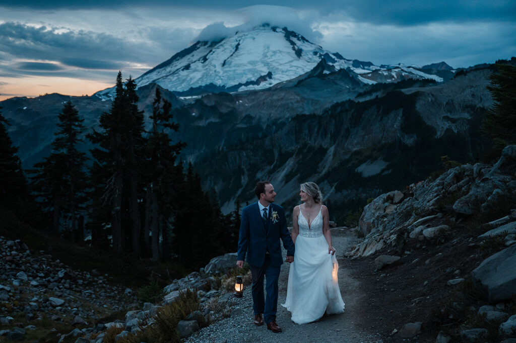 Bride and groom hike at dawn with lanterns in the North Cascades