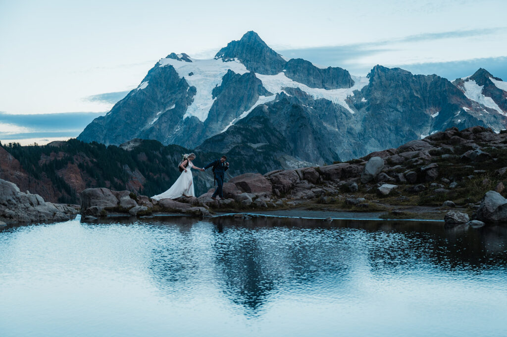 Bride and groom walk along the rocks at Iceberg Lake