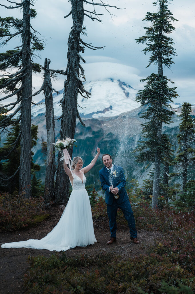 Bride and groom pop champagne after their intimate North Cascades wedding ceremony