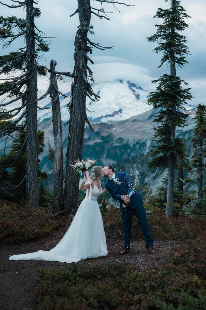 Bride and groom pop champagne after their intimate North Cascades wedding ceremony