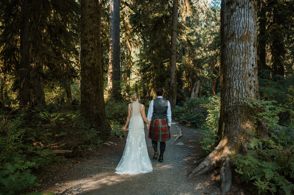 Bride and groom walk into the Hoh Rainforest Hall of Mosses