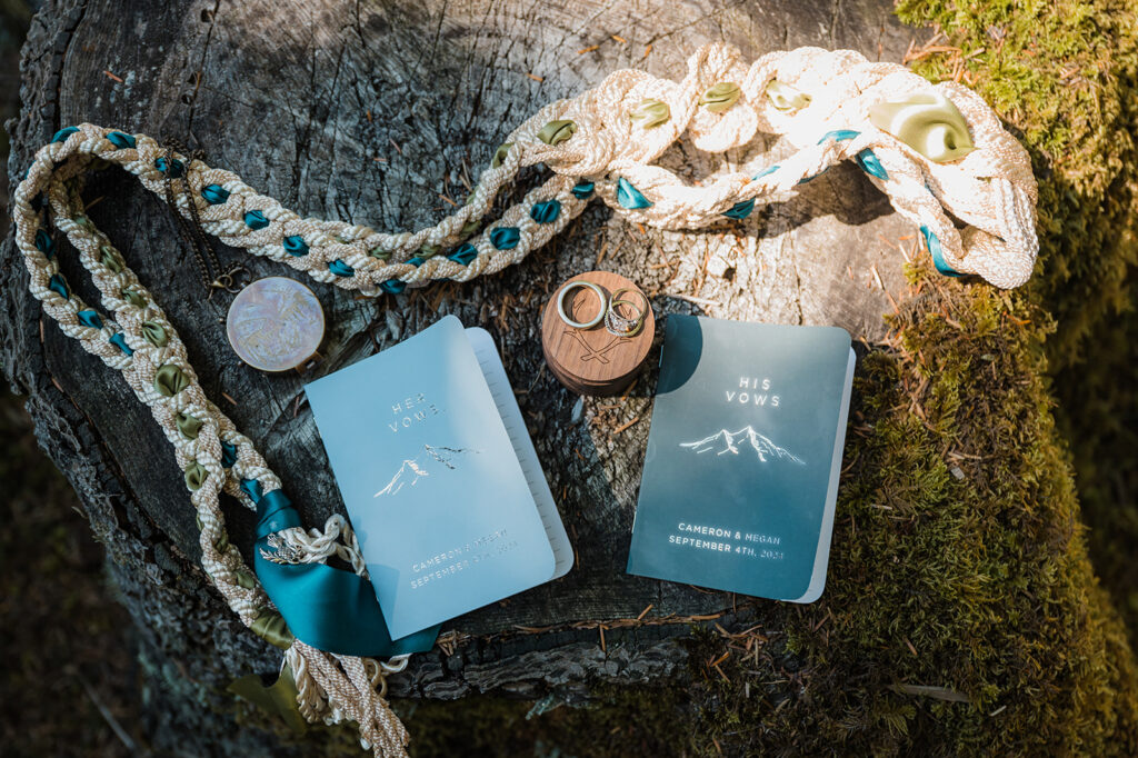 Wedding details including vow books on a stump in Olympic National Park 