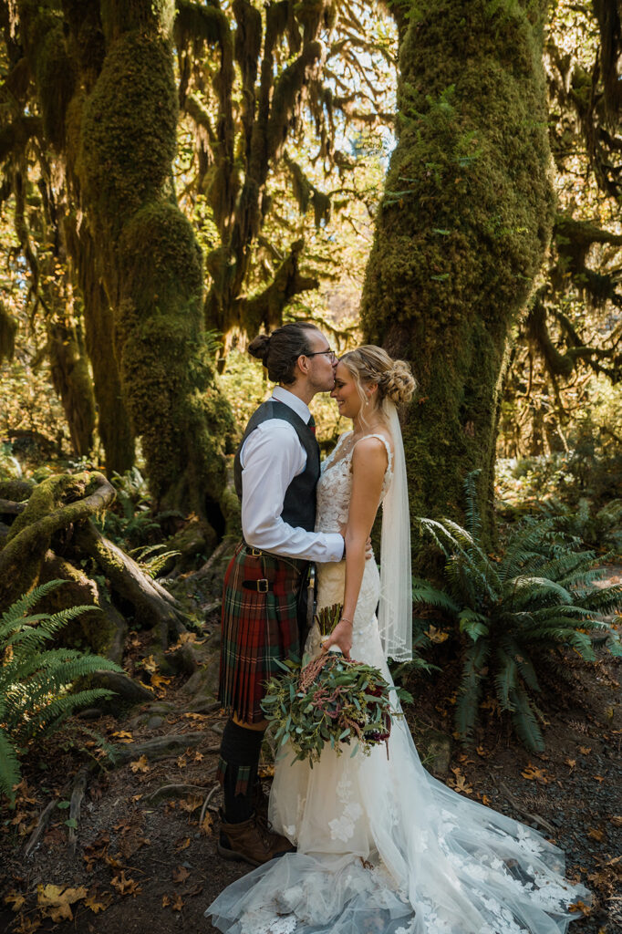 Bride and groom take portraits the Hoh Rainforest Hall of Mosses