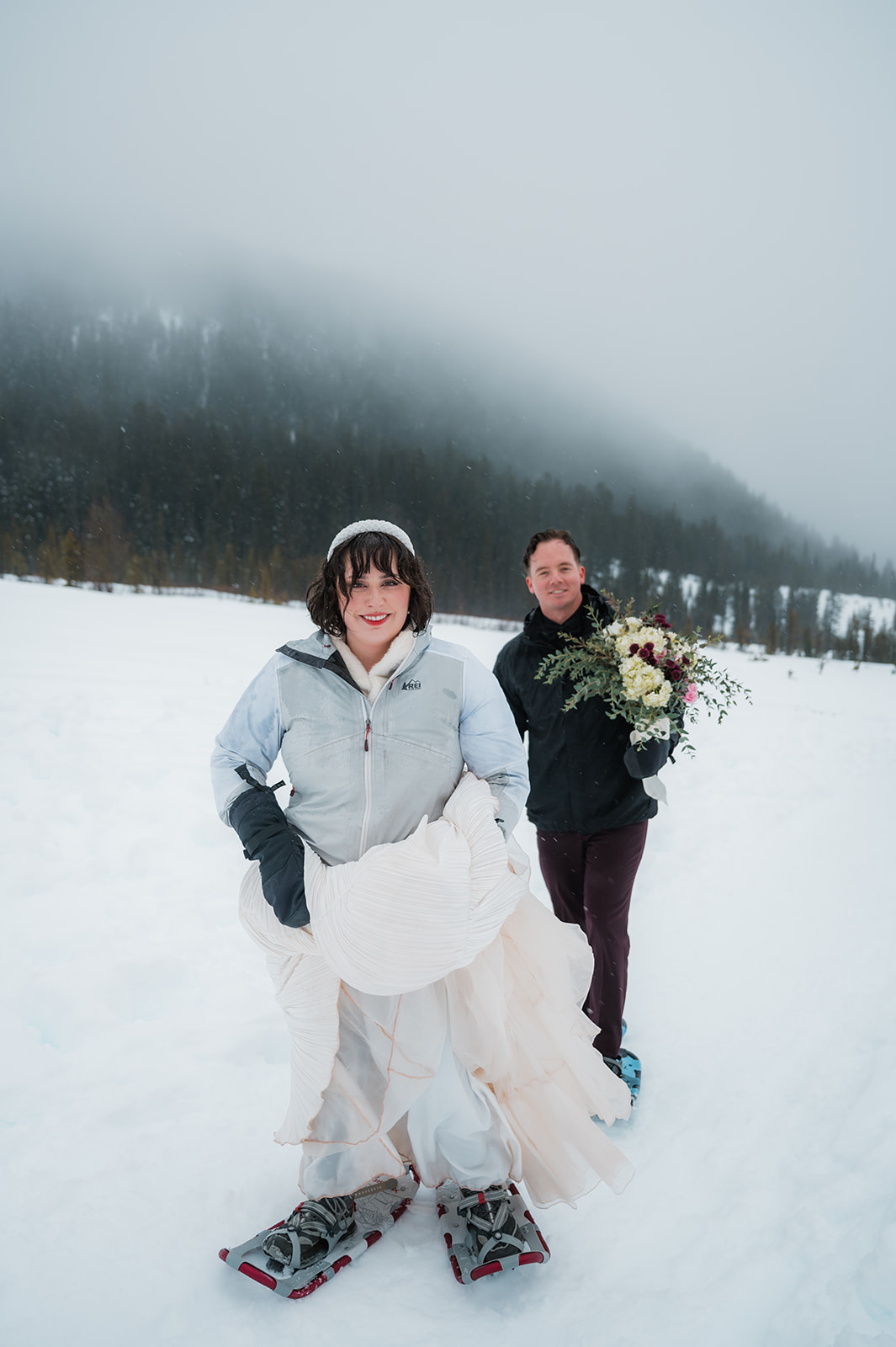 couple snowshoeing in their wedding attire during their winter elopement day in Oregon