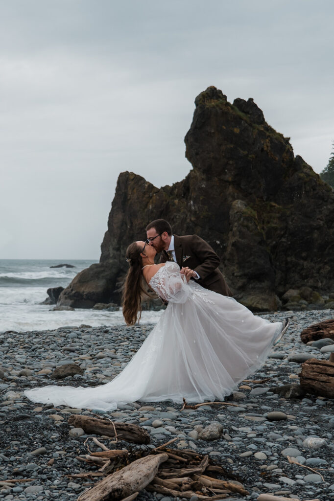 Bride and groom exchanging vows at sunset on Ruby Beach, with their closest family members nearby and sea stacks in the background