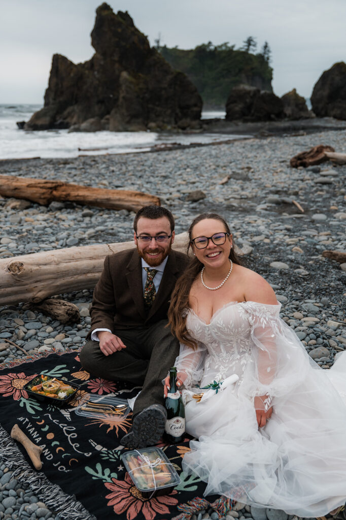 Bride and groom sharing a picnic during their elopement day at Ruby Beach