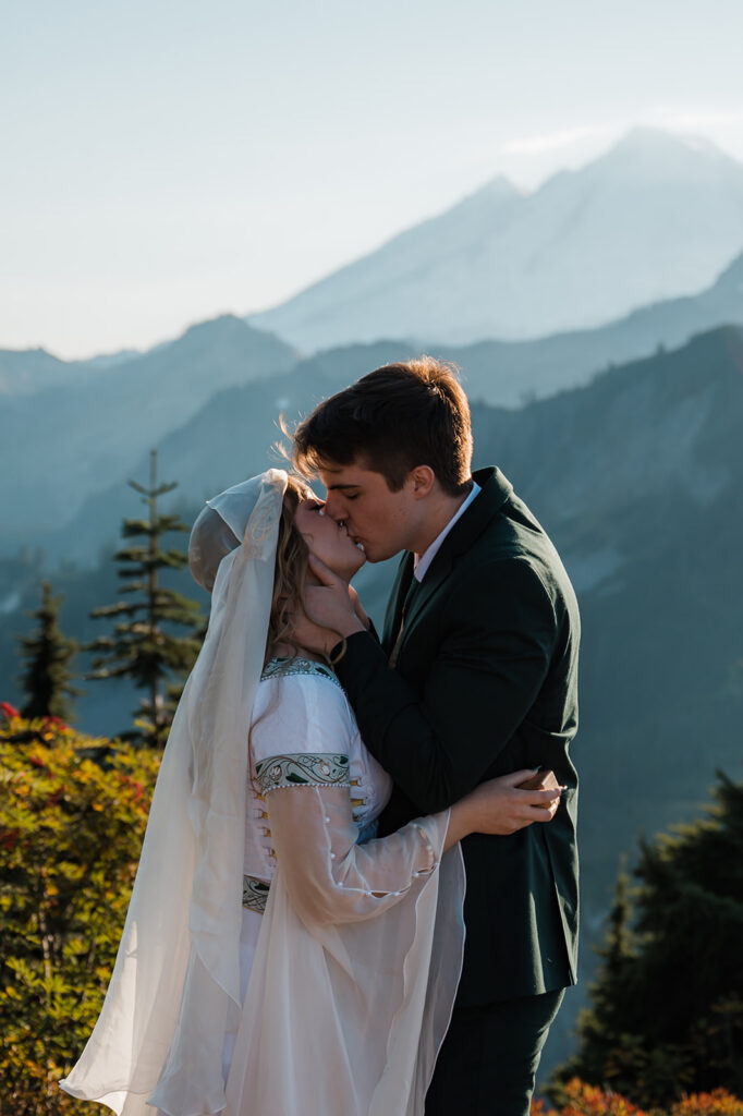 bride and groom sharing their first kiss with views of Mount Baker in the background during their artist point elopement day
