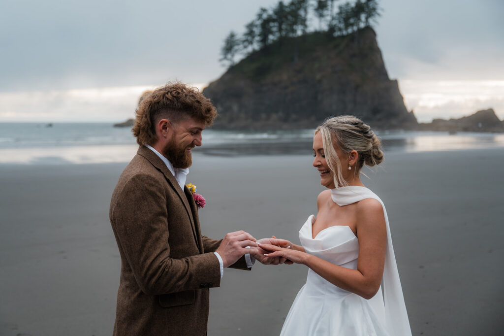 couple exchanging rings during their moody pnw elopement at Second Beach