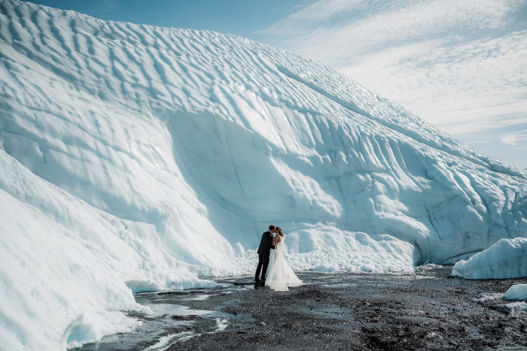bride and groom kissing surrounded by the matanuska glacier