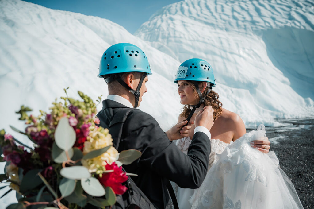 groom helping the bride with her helmet during their alaska glacier elopement 
