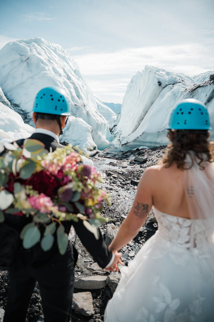 bride and groom holding hands and looking out at the matanuska glacier on their elopement day in alaska