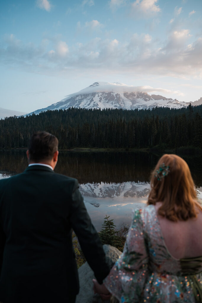 couple watching the sunrise over reflection lake during their mt. rainier elopement day