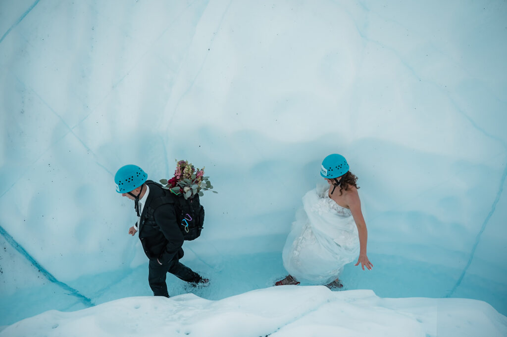 adventurous bride and groom walking up a glacial river on their alaska glacier elopement day 