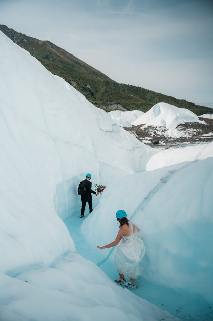 adventurous elopement couple walking through a glacial river on the matanuska glacier