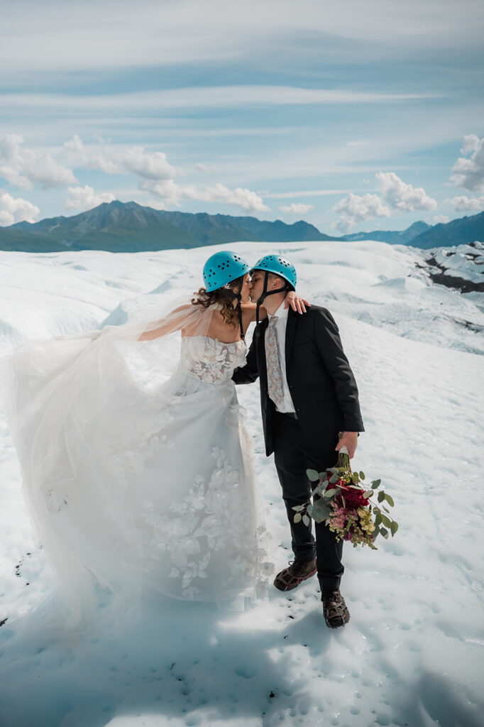 bride and groom sharing a kiss on their helicopter elopement day in alaska